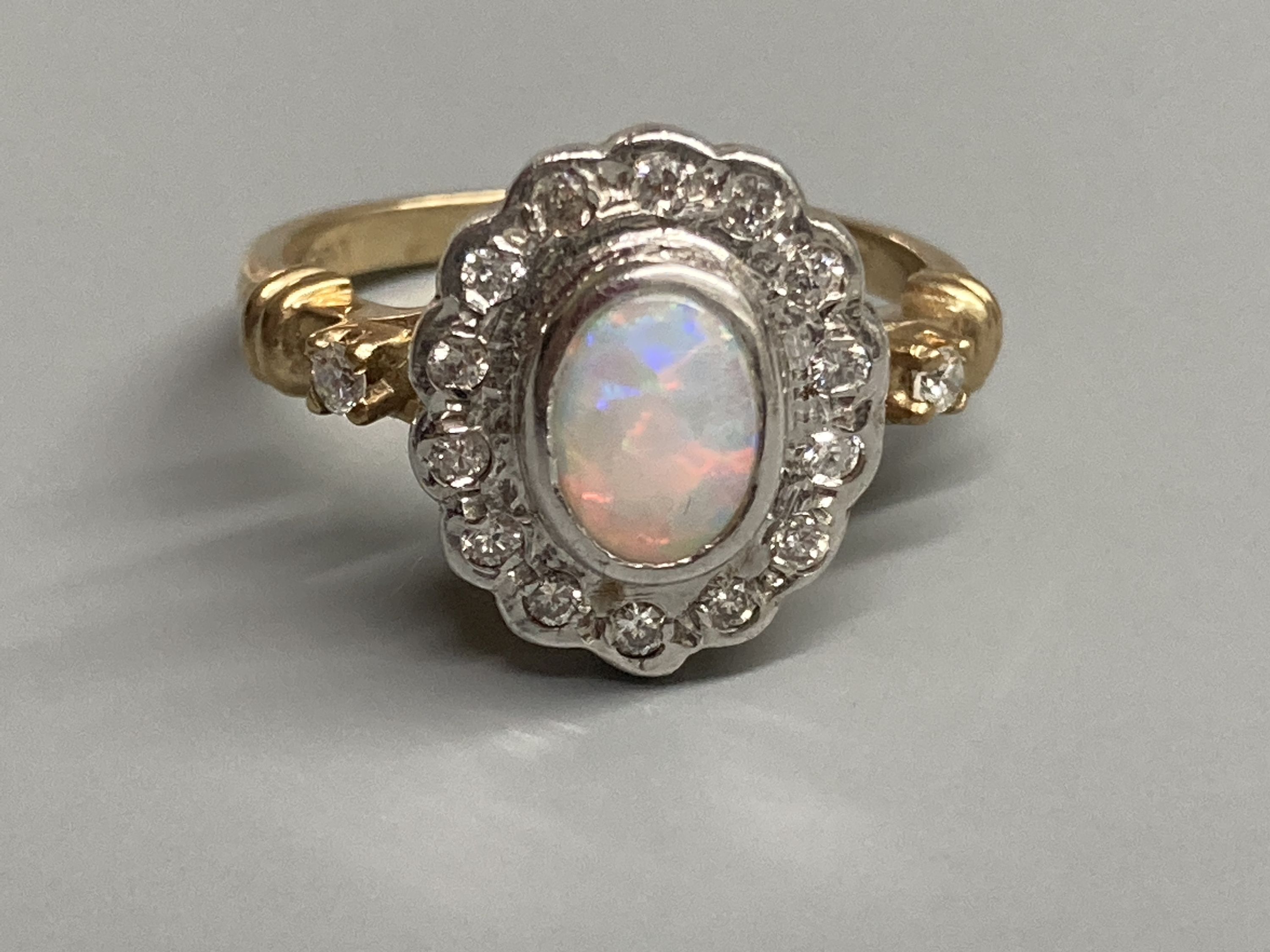 A modern 9ct gold, white opal and diamond chip set cluster ring, with diamond set shoulders, size O, gross 4.4 grams.